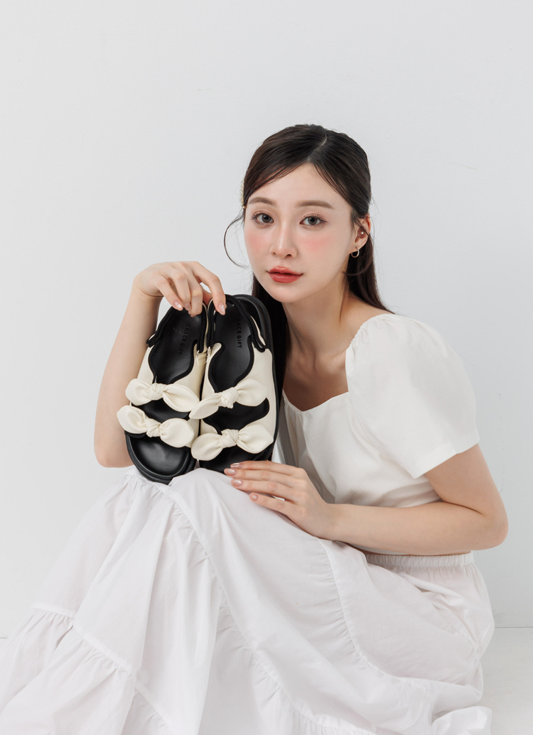 GraceGift平價女鞋 時尚秀場 圓頭 休閒甜感雙蝴蝶結可調節平底涼鞋 米白色
